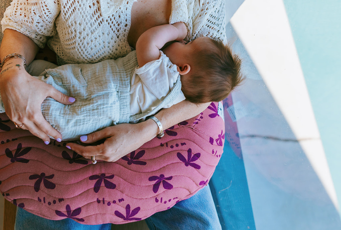 Maman allaitant son bébé confortablement avec un coussin d’allaitement ergonomique